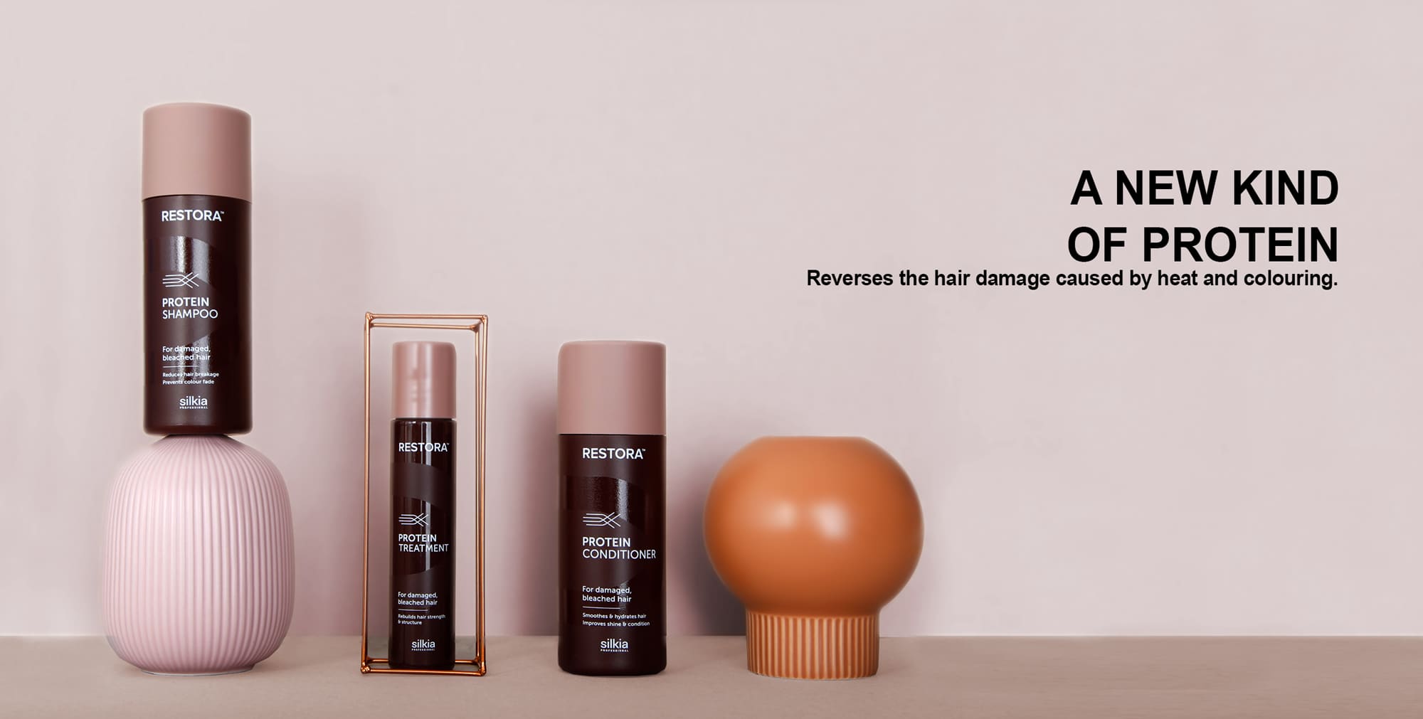 Restora Protein Shampoo, Restora Protein Treatment and Restora Protein Conditioner are shown with props. They reverse the hair damage caused by heat and colouring.